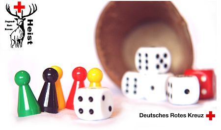 Das Bild zeigt einen Würfelbecher mit Würfeln und bunten Spielfiguren.